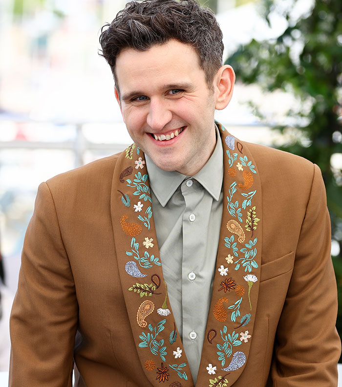 Actor in Harry Potter star in x-rated gay film wearing brown embroidered jacket smiling outdoors