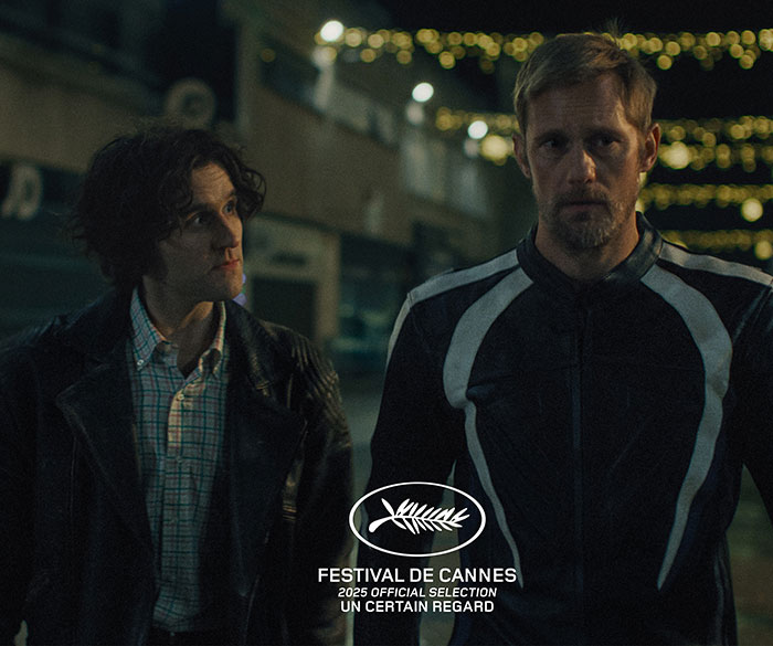 Two men in dark clothing stand outside at night with Festival de Cannes 2025 official selection logo visible on screen.