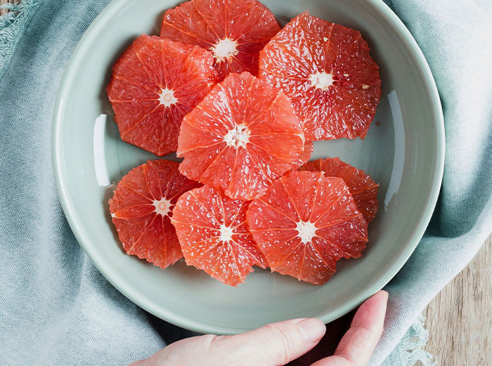 Close-up of sliced citrus fruit in a bowl representing healthy foods to skip according to dentists and doctors online