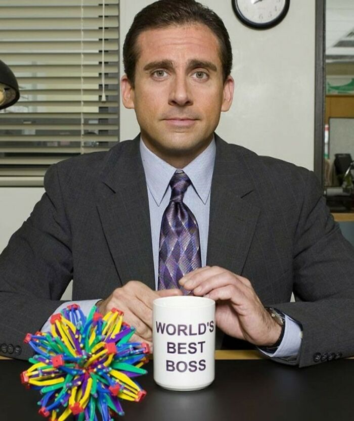 Man in a business suit holding a World's Best Boss mug, illustrating unconventional crushes people actually have.