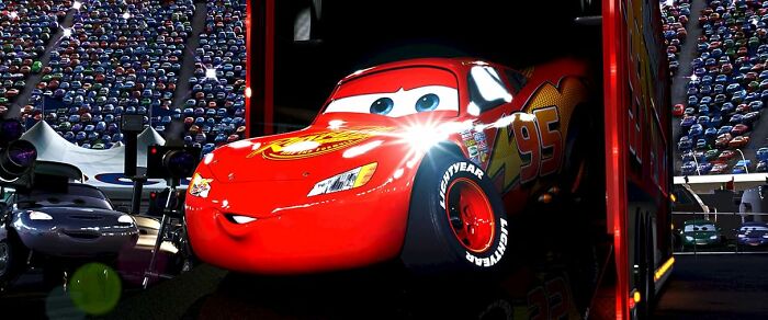 Red animated race car Lightning McQueen with eyes and smile inside a garage, illustrating unconventional crushes concept.
