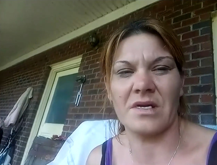 Woman speaking in a video on a porch with a brick wall background, related to 10th body found on suspected serial killer&rsquo;s farm.