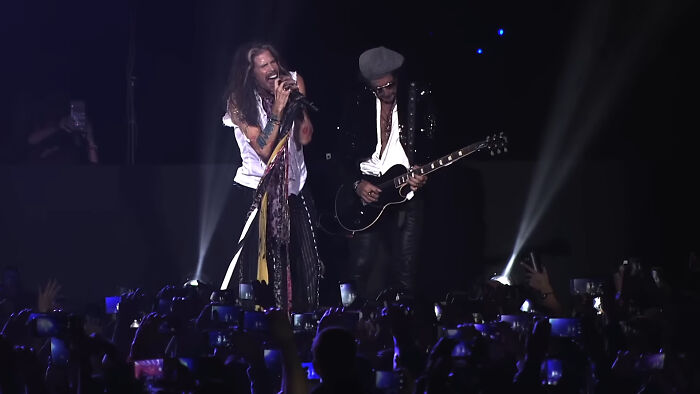 Lead singer and guitarist perform live on stage, capturing the spirit of Gen X with a passionate rock concert experience.