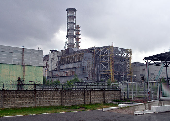 Abandoned nuclear power plant with rusted structures and overcast sky, a site many people keep researching in history.
