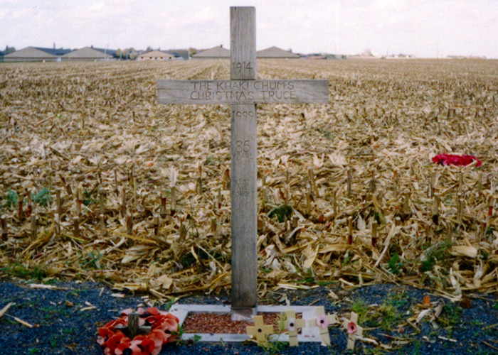 Wooden cross memorial in a field marking a historical event related to the Khaki Christmas truce, a notable historical event.