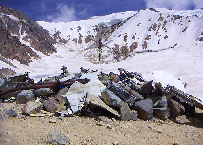 Mountainous snowy landscape with scattered wreckage, a site of past events that people can’t stop researching.