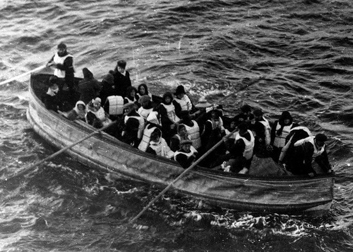 Black and white photo of people rowing a lifeboat on open water, a historic event frequently researched from the past.