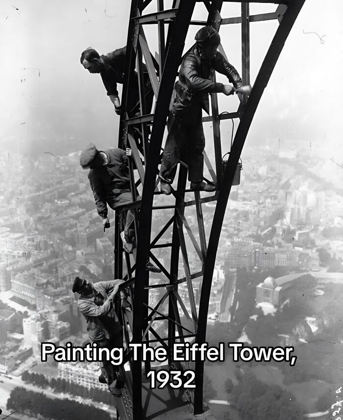 Workers painting the Eiffel Tower in 1932, capturing a monumental life moment frozen in time, historic black and white photo.