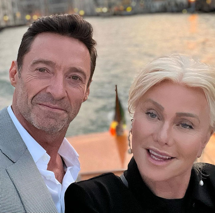Hugh Jackman and Sutton Foster posing outdoors by the water during sunset in a casual selfie.