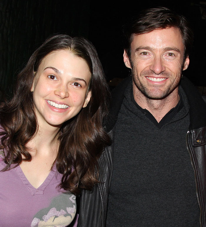 Hugh Jackman and Sutton Foster smiling together in a casual setting, highlighting their long history connection.