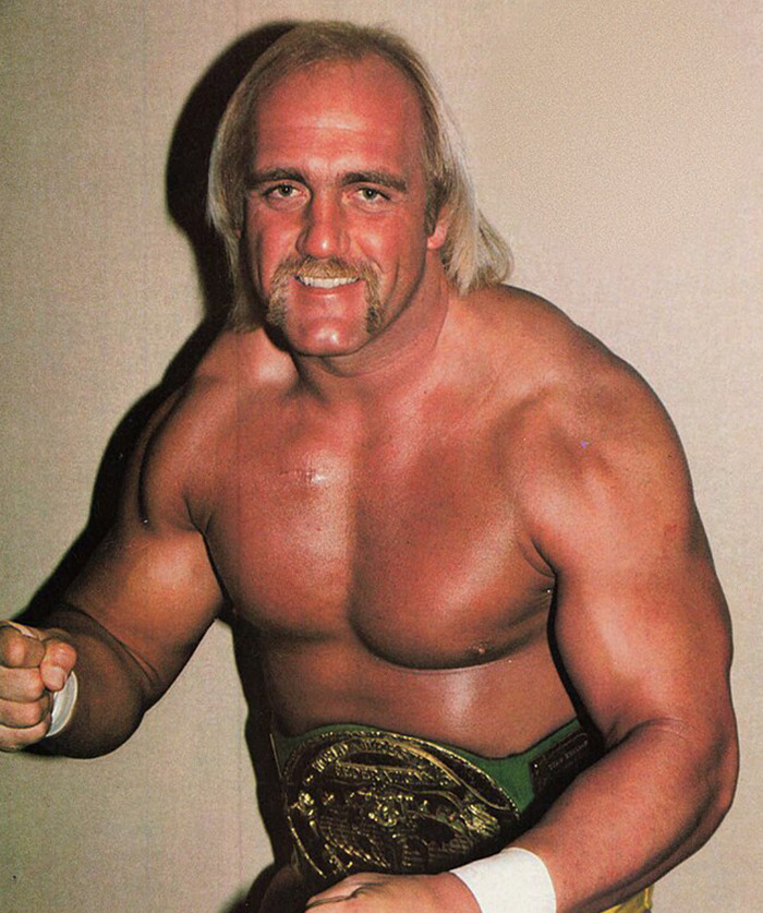 Hulk Hogan posing shirtless with championship belt, showcasing muscular build and intense eyes in a classic wrestling portrait.