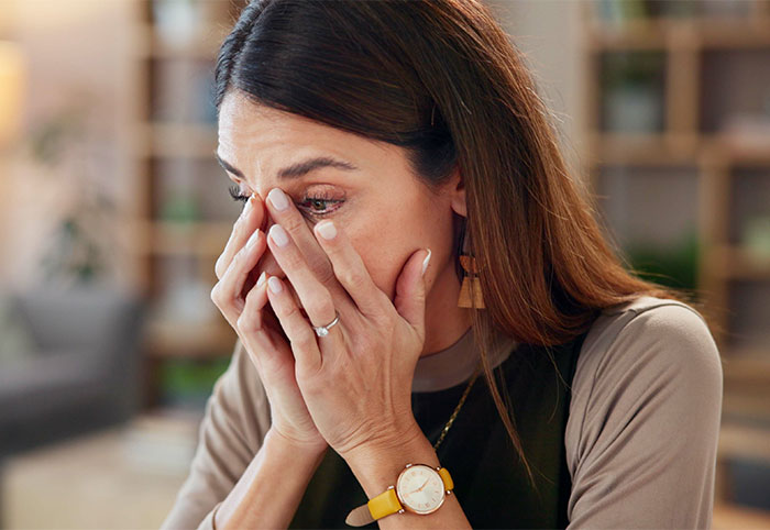 Woman covering her face with hands, looking upset, reflecting emotions related to postpartum weight and spicy photoshoot refusal. Woman covering her face with hands, looking upset, reflecting emotions related to postpartum weight and spicy photoshoot refusal.