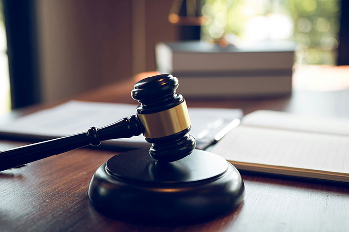 Gavel resting on a wooden desk with open legal notebooks in the background, symbolizing custody and divorce disputes. Gavel resting on a wooden desk with open legal notebooks in the background, symbolizing custody and divorce disputes.