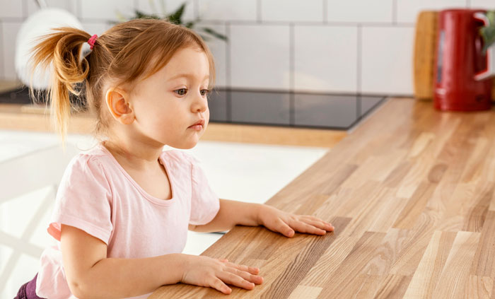 Young girl in kitchen looking concerned while mom tells SIL eating ice cream every night complicates her parenting choices Young girl in kitchen looking concerned while mom tells SIL eating ice cream every night complicates her parenting choices