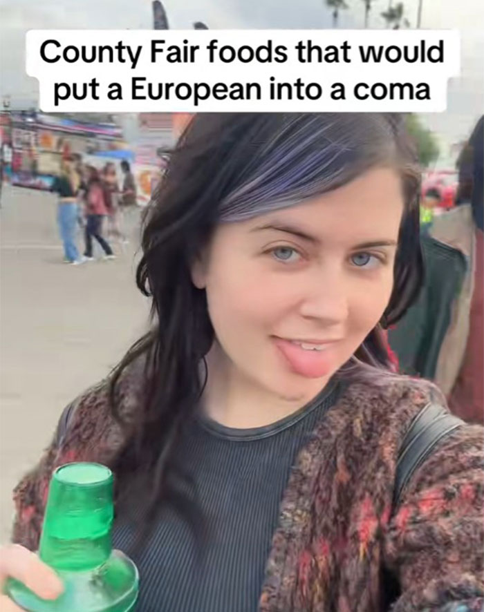 Young woman at a county fair holding a drink, with text about county fair foods that might put a European into a coma.