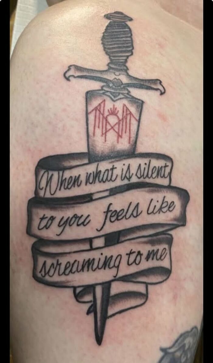 Tattoo of a dagger with a banner reading a misspelled phrase, showcasing a permanent mistake in a cool inked design.