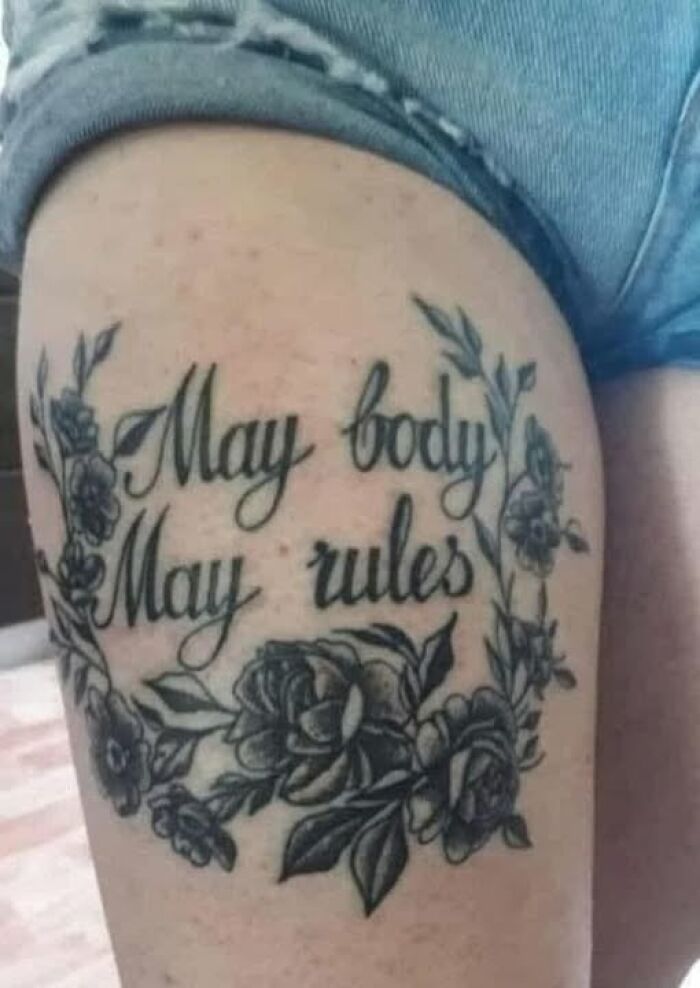 Tattoo with floral design and the phrase May body May rules showing a permanent mistake in inked tattoo.