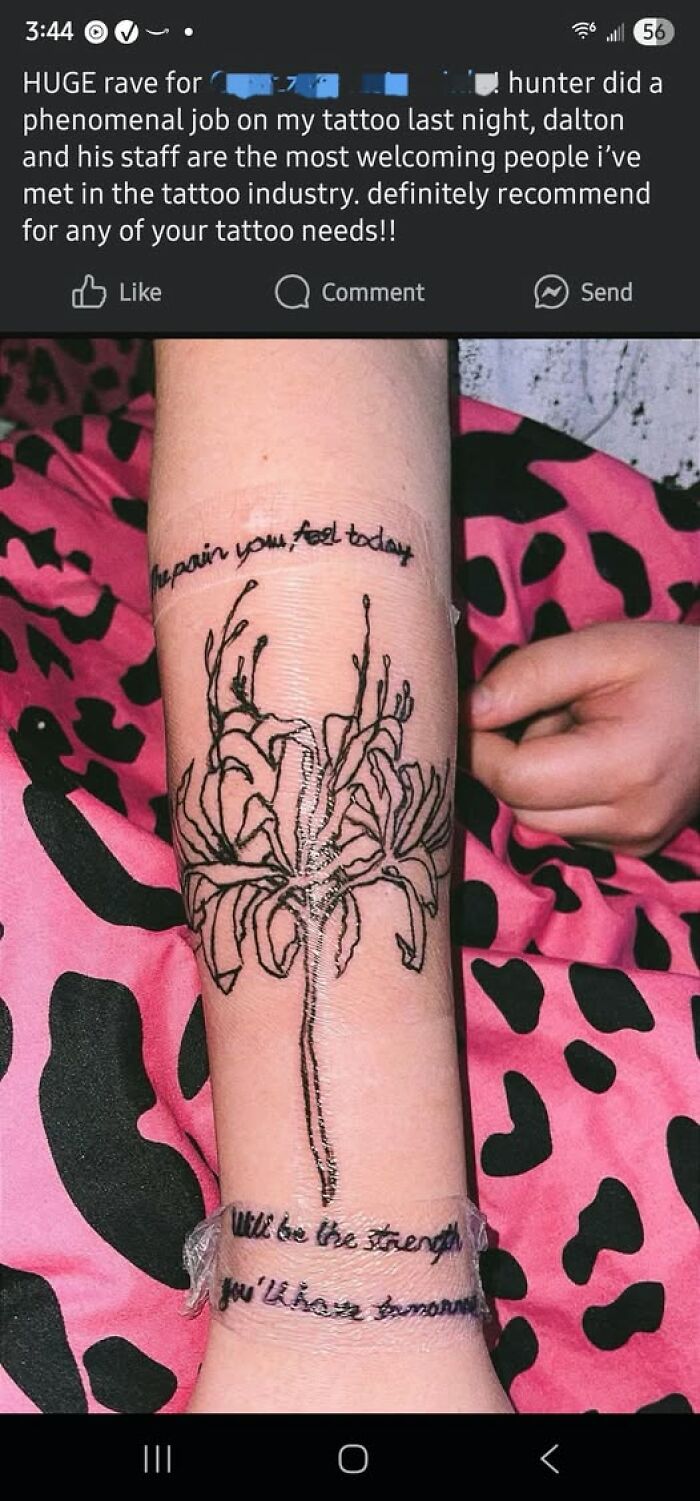 Close-up of a forearm tattoo with a flower design and layered text showing a permanent tattoo mistake.