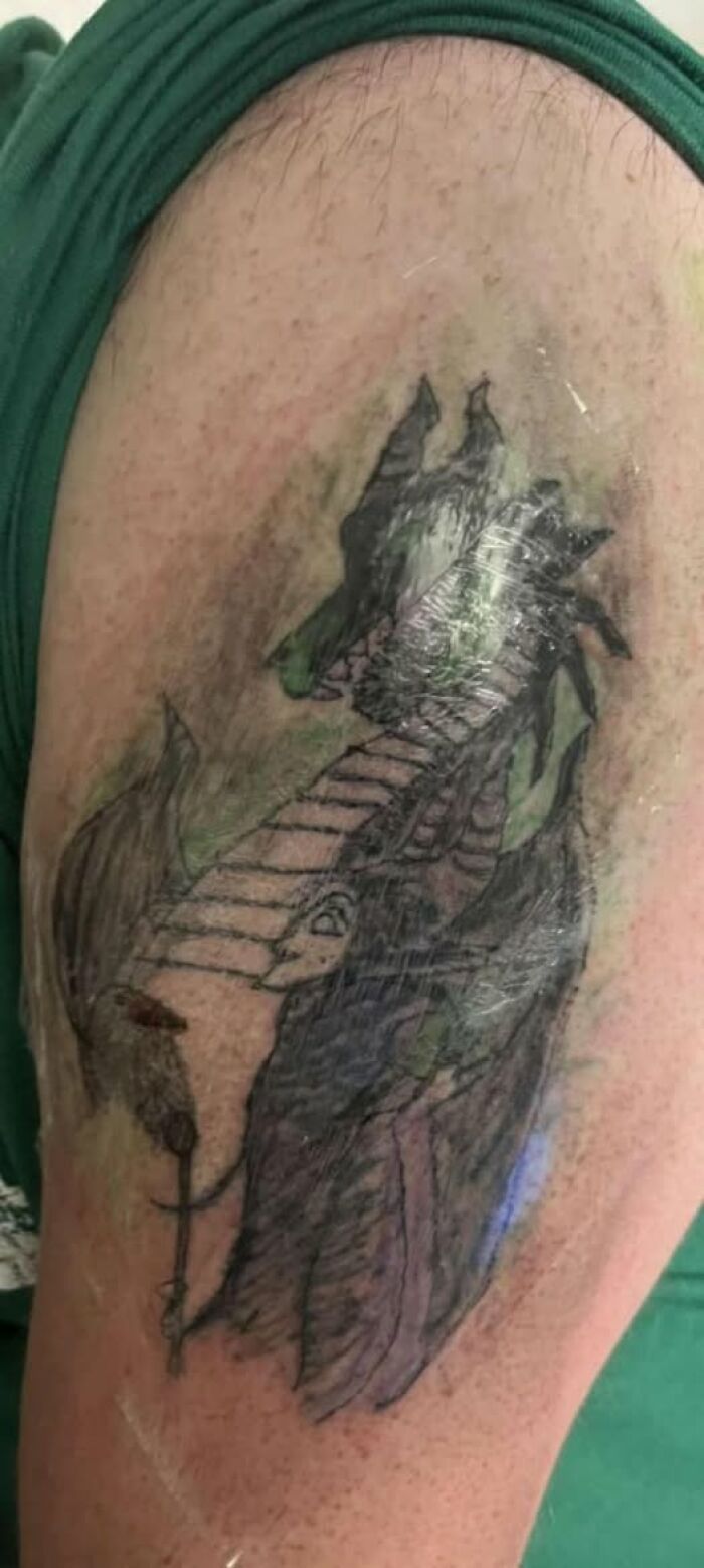 Tattoo of a dragon with uneven shading and unclear details, highlighting a cool inked design with a permanent mistake.