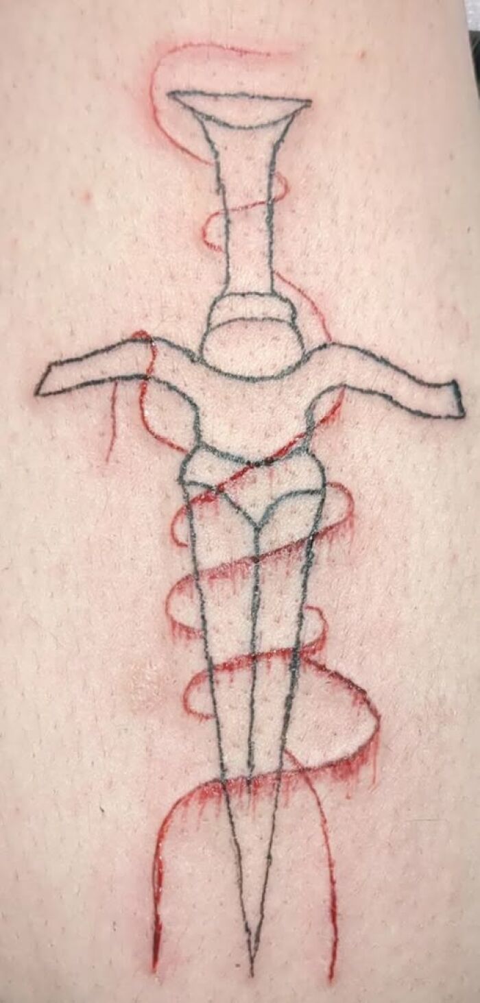 Tattoo of a dagger with a figure wrapped in red ink lines, showing a permanent mistake in the inked design.