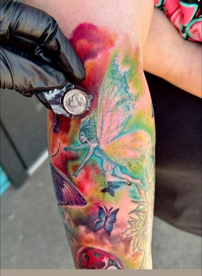 Colorful tattoo on arm featuring a fairy and butterflies, illustrating people who got inked but ended up with a permanent mistake.