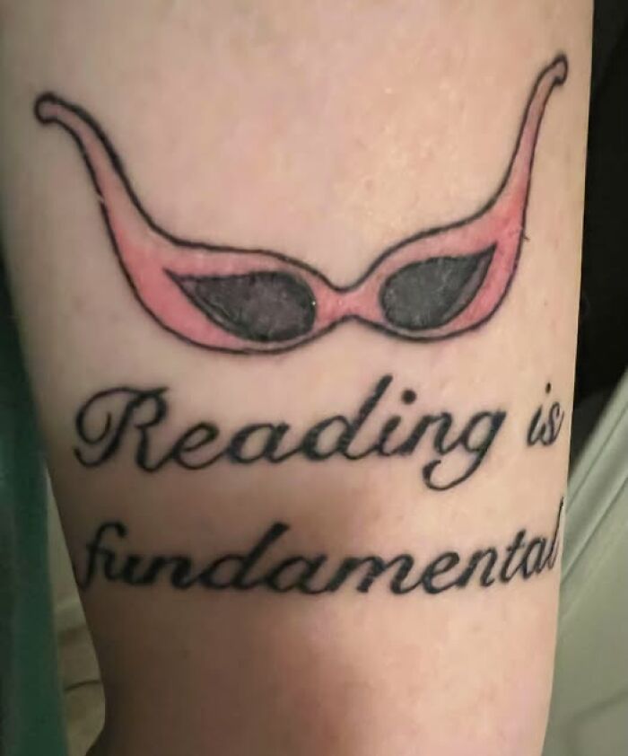 Tattoo of pink sunglasses above a misspelled phrase showcasing a permanent mistake in an inked design.