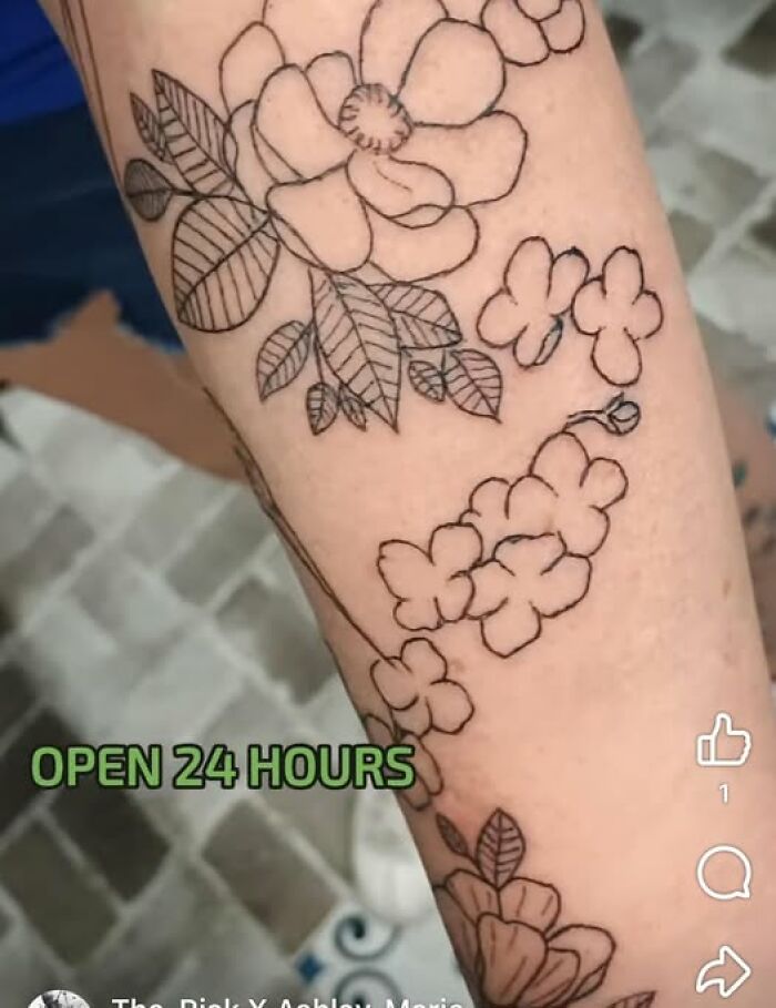 Floral tattoo with black outline inked on forearm showing a permanent mistake in design and placement.