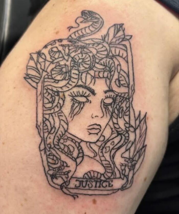 Tattoo of a Medusa-like figure with snakes for hair and the word justice, an example of inked mistakes meant to look cool.