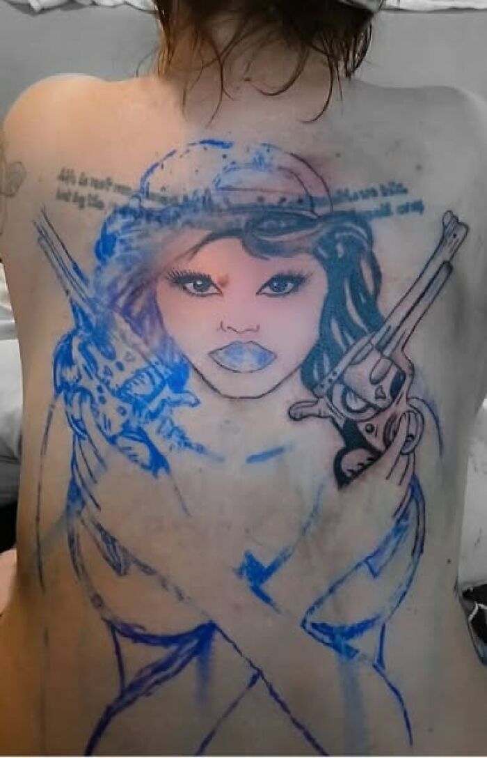 Tattoo of a woman holding guns on a person's back, showcasing a permanent mistake in inked body art.