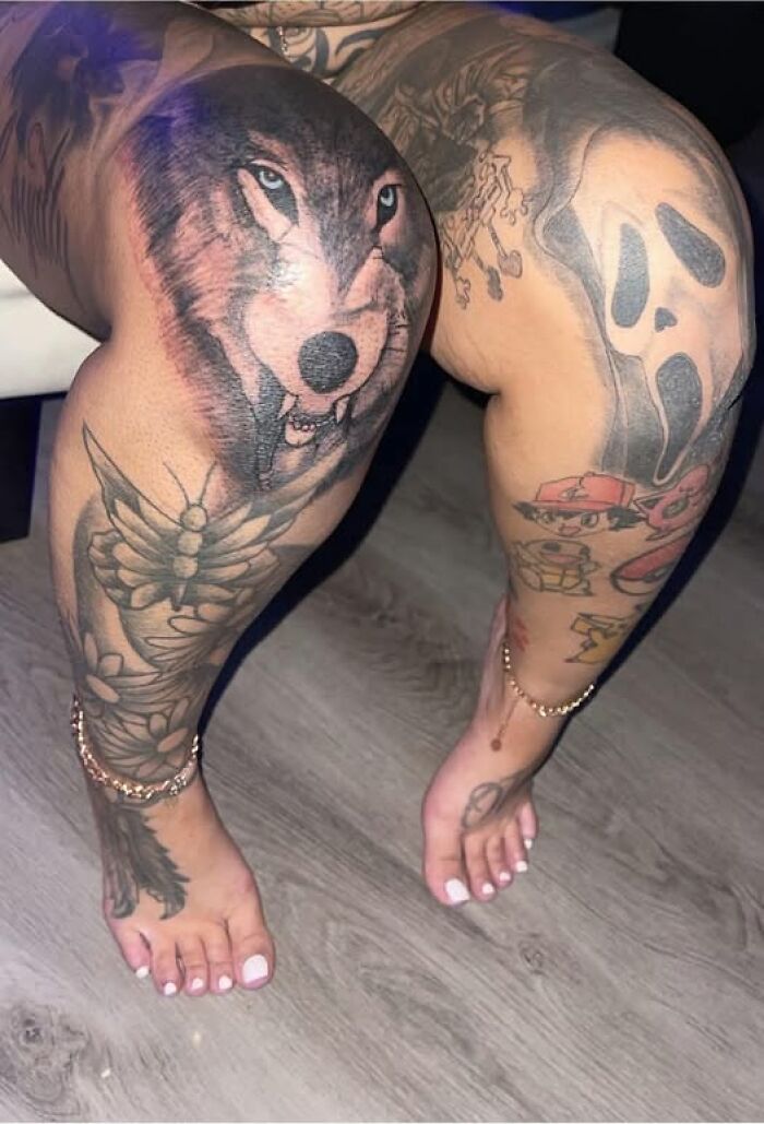 Legs covered in multiple tattoos including a wolf, butterfly, and various designs, showcasing inked permanent mistakes.
