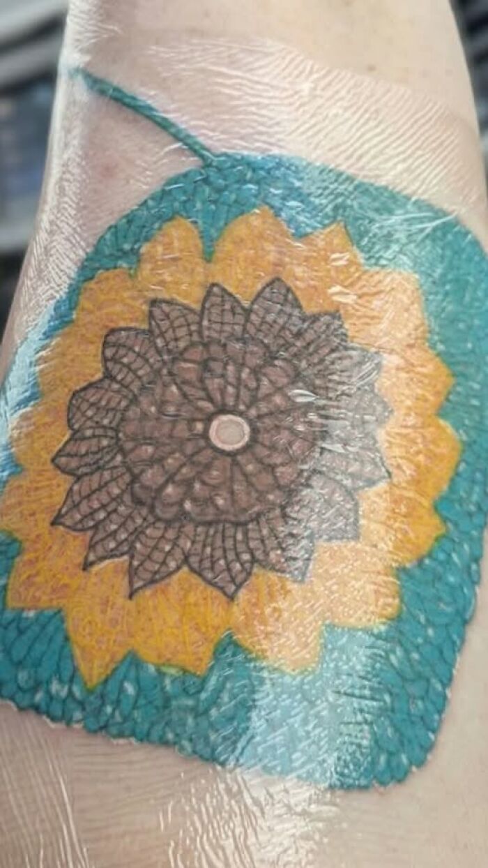 Close-up of a colorful tattoo covered in plastic wrap, showcasing a design that may be a permanent mistake in inked tattoos.