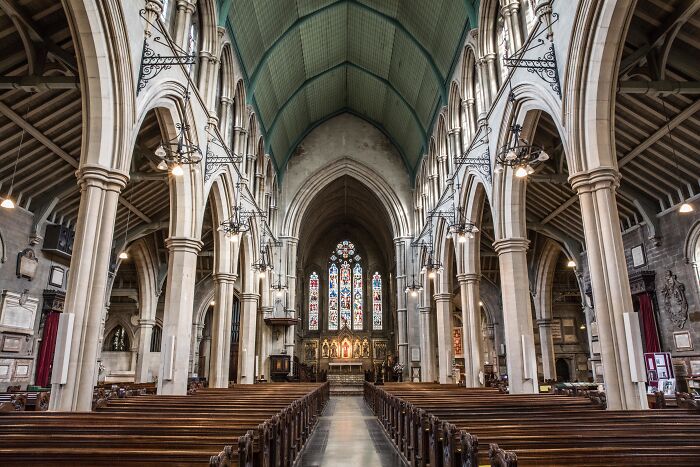 Interior of a large historic church with stained glass windows and wooden pews, highlighting unusual ways to earn quick money.
