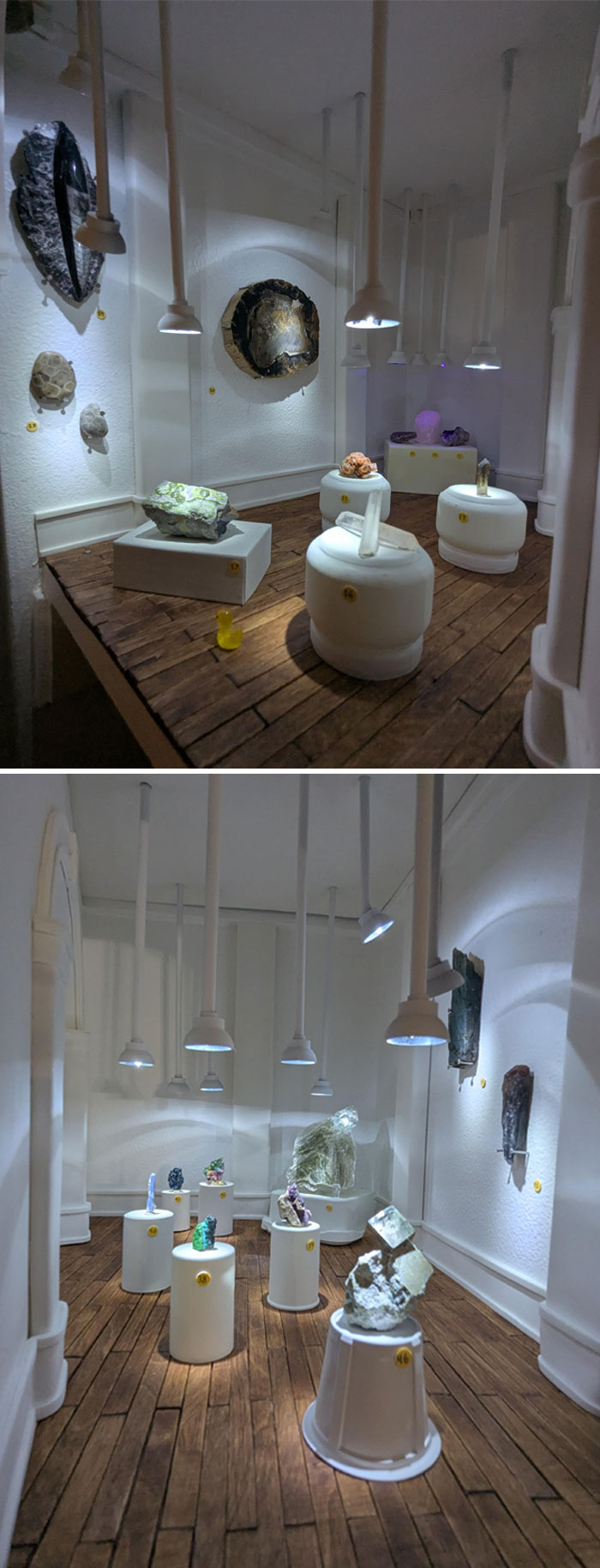 Miniature indoor display of unusual mineral and rock collections on pedestals under spotlights with wooden flooring