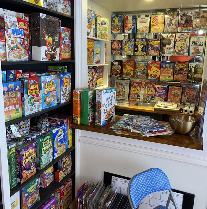 Collection of unusual and interesting cereal boxes displayed on shelves and walls inside a home room.