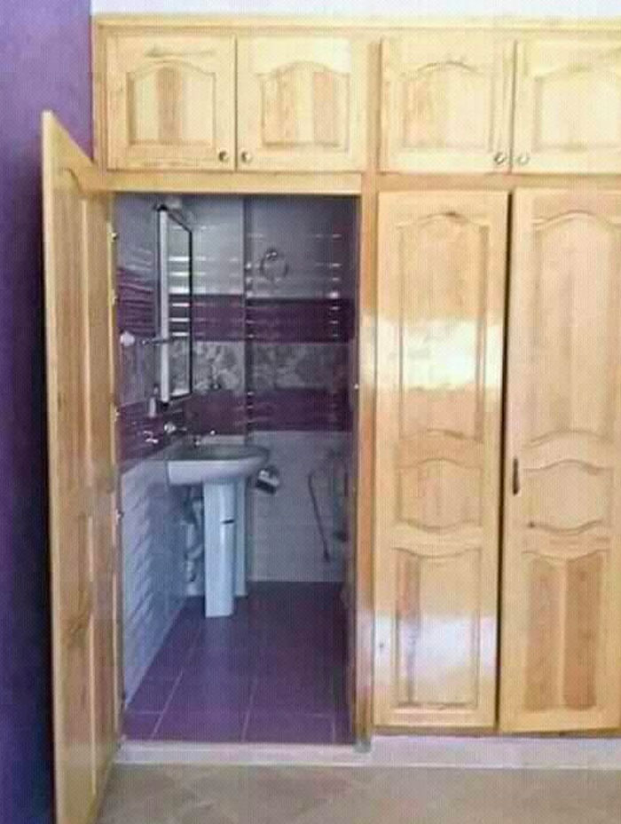 Closet doors opening into a small bathroom with sink and mirror, showcasing dumb interior design decisions.