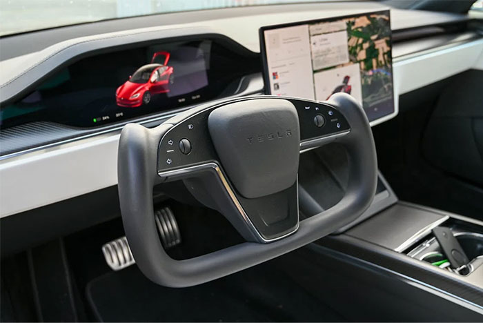 Tesla futuristic steering wheel and digital dashboard display showcasing technology changing humanity in next 10 to 15 years.
