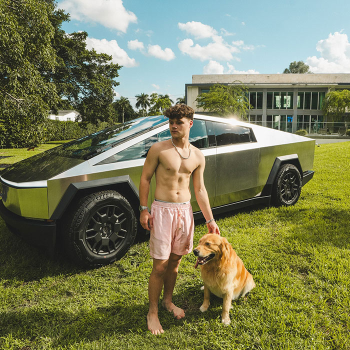 Jack Doherty outdoors with dog standing next to futuristic car, reflecting Jack Doherty net worth and success keywords.