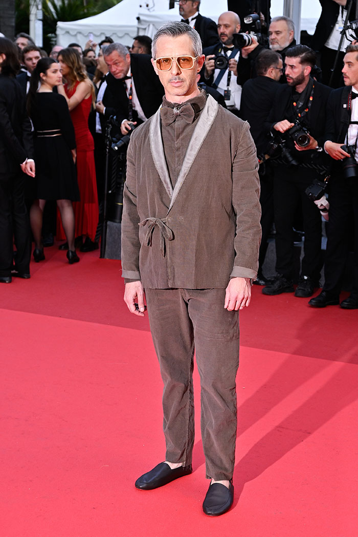 Man wearing brown mismatched outfit and yellow glasses on the red carpet of Cannes Film Festival 2025 fashion disasters.