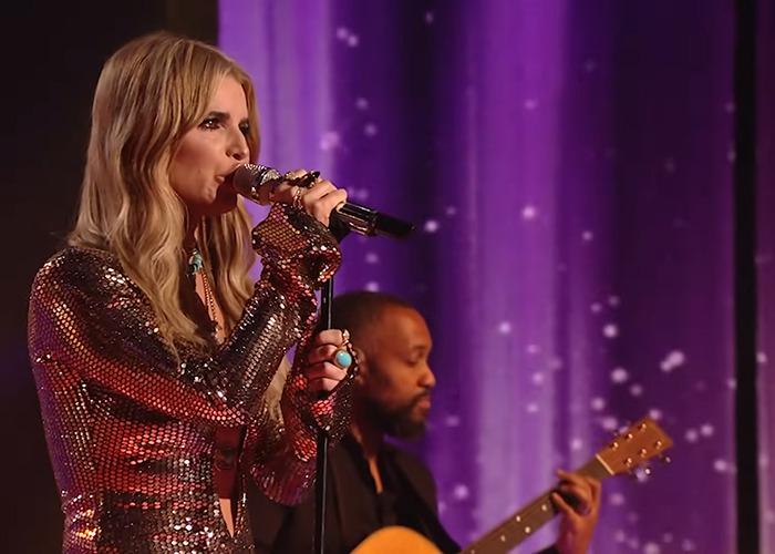 Jessica Simpson performing live on stage with sparkling outfit and guitarist during first TV show in 15 years.