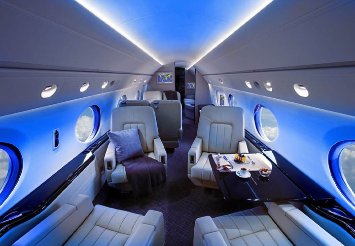 Private jet interior with luxurious seating and dining setup, highlighting Jim Carrey&rsquo;s net worth and mansion drama topics.