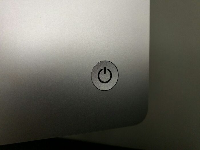 Power button close-up on a metallic device surface, symbolizing industry secrets revealed behind closed doors.