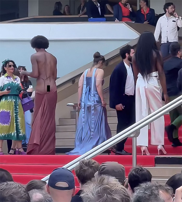 Star revealing backside on the Cannes red carpet breaking dress code, drawing attention and mass applause from the crowd.