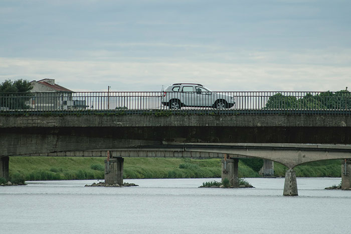 A car stopped on a bridge over calm water, illustrating precautionary measures that saved lives shared online.