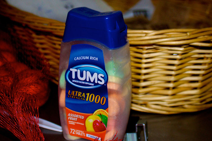 Bottle of Tums antacid tablets on a kitchen counter representing precautionary health measures that saved lives.