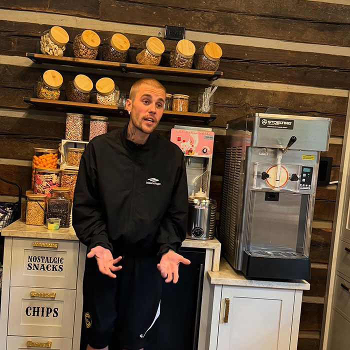 Justin Bieber standing in a snack shop kitchen, triggering fiery parenting debate over smoking with his son.