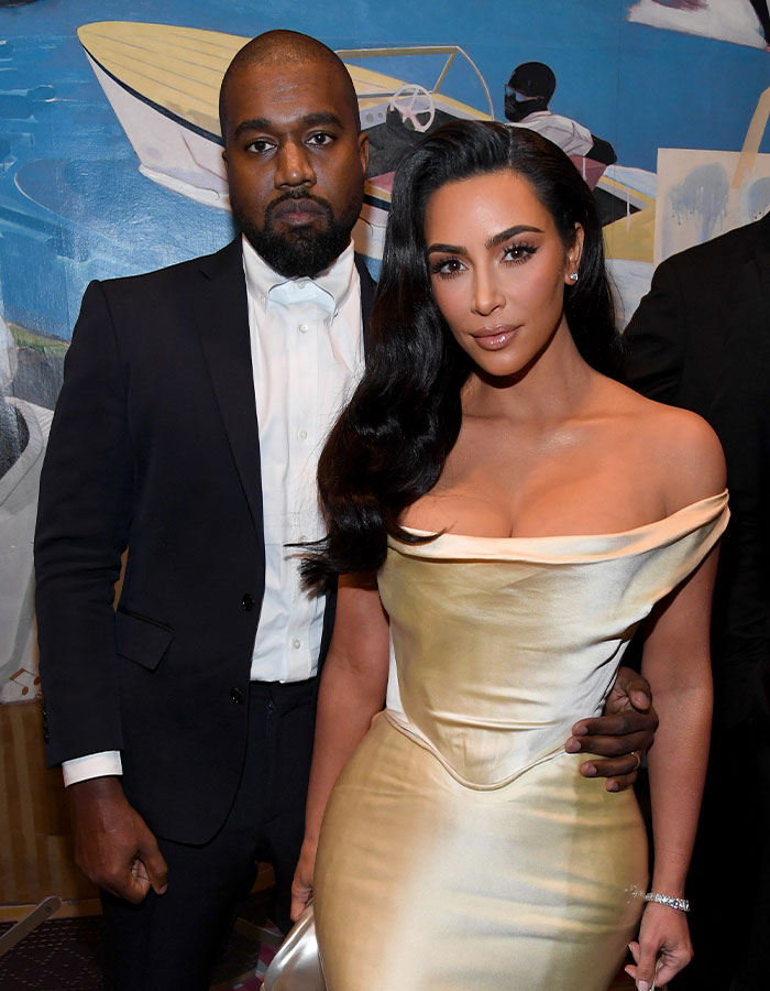 Woman with dramatic hair makeover wearing a gold off-shoulder dress at an event, standing next to a man in a black suit. Woman with dramatic hair makeover wearing a gold off-shoulder dress at an event, standing next to a man in a black suit.