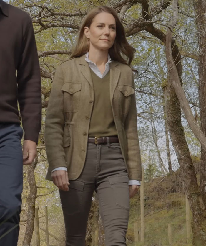 Kate Middleton walking outdoors wearing a jacket and trousers, with editing accusations about right hand belonging to a male.