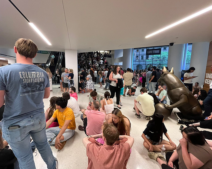 Crowd of people sitting and standing in a large indoor space during Katy Perry's world tour setback event. Crowd of people sitting and standing in a large indoor space during Katy Perry's world tour setback event.