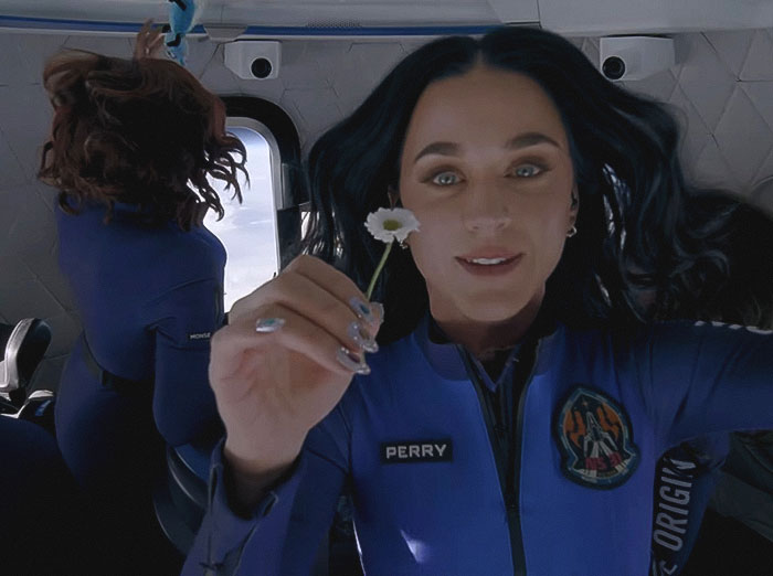 Katy Perry in astronaut suit holding a flower during a space mission, highlighting her world tour setback. Katy Perry in astronaut suit holding a flower during a space mission, highlighting her world tour setback.