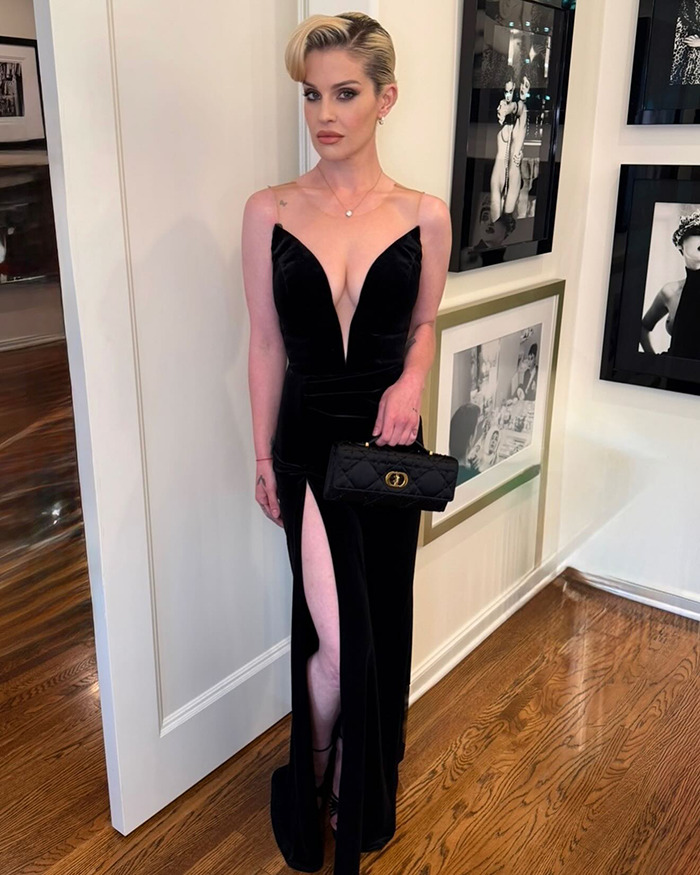 Kelly Osbourne in a sleek black gown holding a purse, showcasing her stunning transformation amid Ozempic and plastic surgery rumors.